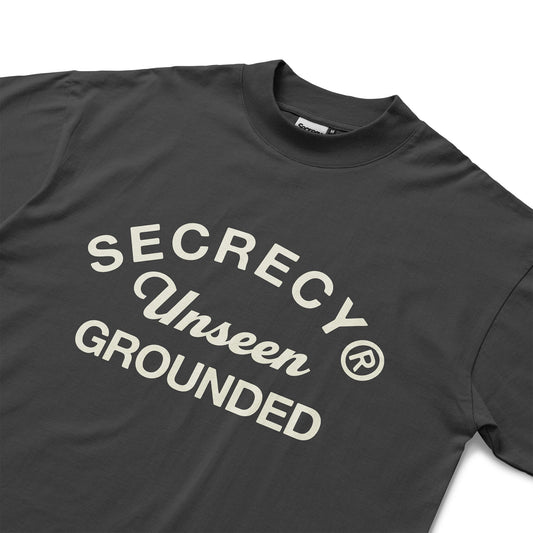Black t-shirt with 'Secrecy Unseen Grounded' text on a white background